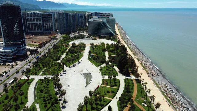 Amazing aerial view of the lech and maria kaczynski park in batumi, georgia, featuring modern architecture, lush green spaces, and the beautiful black sea coastline on a sunny summer day