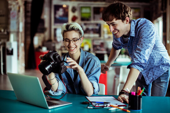 Photographer reviewing shots with colleague in creative studio