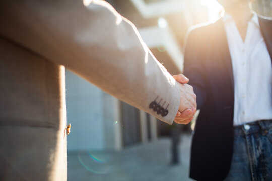 Business professionals shaking hands outside an office
