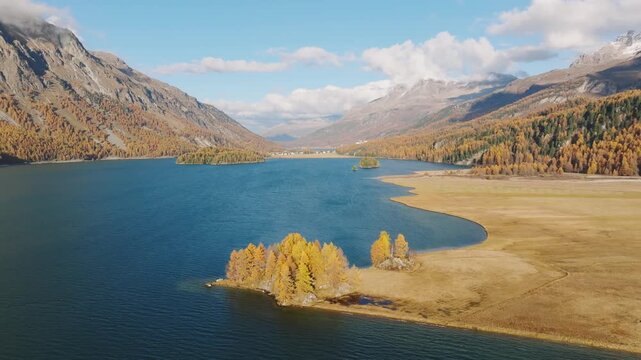Drone view of a mountain and lake in the Engadin valley, Switzerland. Autumn landscape from the air. Panoramic view. Sunny day in the mountains. 