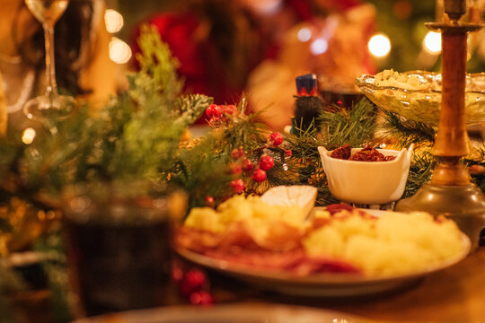 Festive holiday table setting adorned with greenery, delicious food, and warm ambient lighting, creating a cozy atmosphere for seasonal gatherings and celebrations