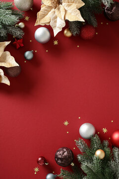 Vertical Christmas background with baubles and fir branches on red
