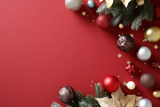 Christmas baubles and pine branch on red background