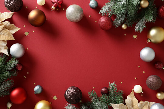 Christmas baubles and fir branches on red background