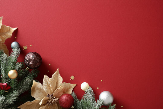 Christmas background with baubles and fir branches on red