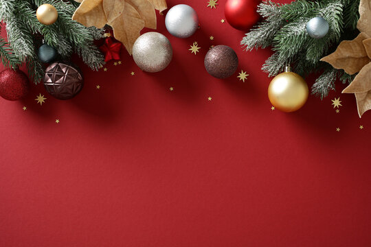 Christmas background with baubles and pine branch on red surface