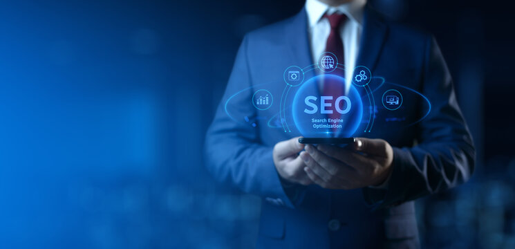 Businessman holding smartphone with Search Engine Optimization SEO icons on screen - Digital Marketing Concept