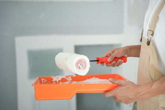 painter man, brush in hand for products to restore and paint the wall, indoor the building site of a house, wall during painting, renovation, painting, contractor, Architect, construction worker