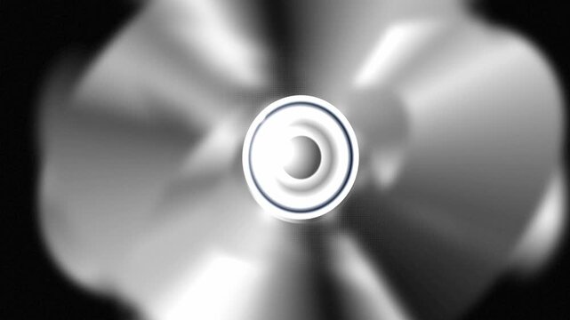 Metallic chrome ring rotates with blurred motion trails over a dark textured surface in an abstract 3D animation