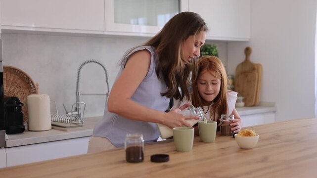 Mother and daughter making coffee and hot cocoa in the kitchen