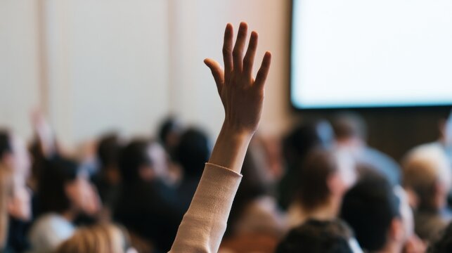 Audience member raises hand during a discussion in a large conference room at a business event