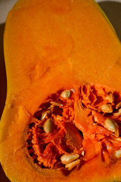 close-up of fresh orange butternut squash cut in half showing seeds and fibrous interior texture
