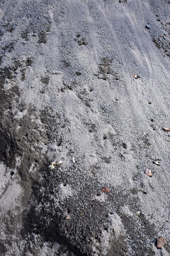 close up of dark volcanic ash and gravel texture on rocky ground outdoors