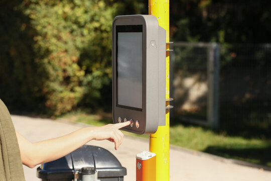 Hand dr&uuml;ckt Taste an digitalem Fahrgastinformationsterminal an Bushaltestelle. Display, &Ouml;PNV, &ouml;ffentliche Verkehrsmittel, urban, Technologie, Deutschland.