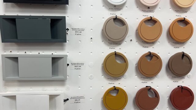 Desk cable grommets and wire hole covers display on pegboard in furniture store