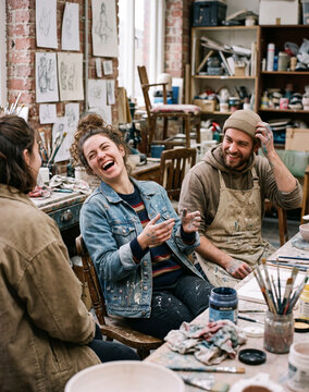 Diverse Group of Artists Laughing Together in Creative Art Studio   
