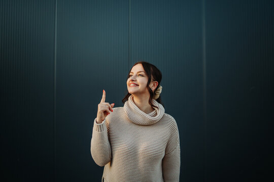 Woman smiling pointing finger up having idea