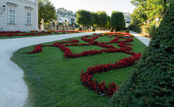 Formal garden with red flower beds and clipped hedges