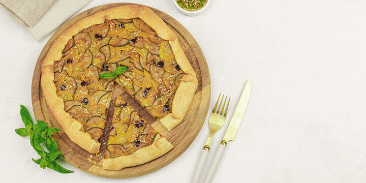 Baked rustic zucchini galette slices on garnished with fresh basil. Homemade savory vegetable tart