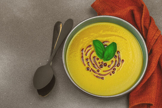 Creamy pattypan squash soup, garnished with basil and balsamic glaze, served in a trendy bowl