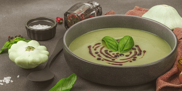 Creamy pattypan squash soup, garnished with basil and balsamic glaze, served in a trendy bowl