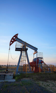 Oil extraction machinery on dramatic silhouette sunset. Industrial landscape mood. Pumpjack in oil well of oil field on sunrise in Industrial crude area. Crude pump jack 