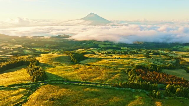 Mount Pico and Green Pasturelands at Sunrise. Faial Island, Azores. Portugal. Aerial Shot. View from Cabeco Gordo Viewpoint. Moving Forward, Tilt Up. Reveal Shot
