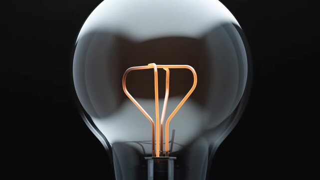 Incandescent Light Bulb Filament Gradually Glows in a Dark Studio Setting