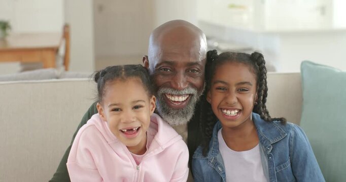 African American family laughing as senior leaning forward, teasing on light sofa at christmas