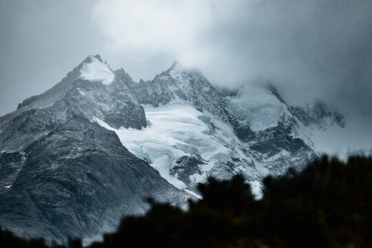 View of the snow-capped peaks of the Andes mountains shrouded in dramatic clouds near El Calafate, Santa Cruz Province, Argentina.