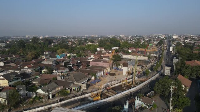Aerial view of a construction site with cranes and concrete structures in an urban area of Yogyakarta, Special Region of Yog, Indonesia.