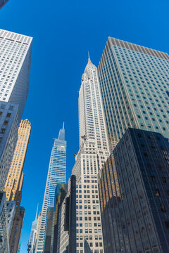 Vertical Manhattan skyscrapers under a blue sky