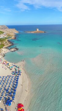 Captivating sights of La Pelosa Beach in Sardinia, Italy, showcasing golden sands, blue waters, and vibrant umbrellas under a clear sky, inviting relaxation and enjoyment on a perfect day.