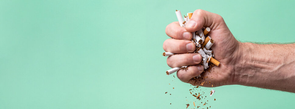 Male hand crushing cigarettes, quitting smoking and healthy lifestyle