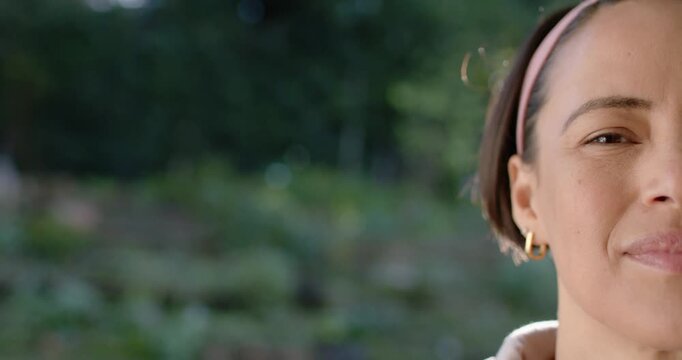 African American woman shifting into frame smiling and laughing in garden, pink headband