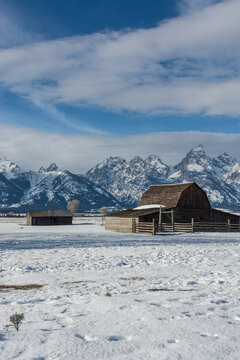 View of the historic Mormon Row barns in Jackson Hole set against the snow-covered Teton Range in Teton County, Wyoming, United States.