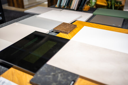 Countertop and cabinet samples are arranged together to compare colors and finishes. Material matching for kitchen design is shown with selective focus and shallow depth of field