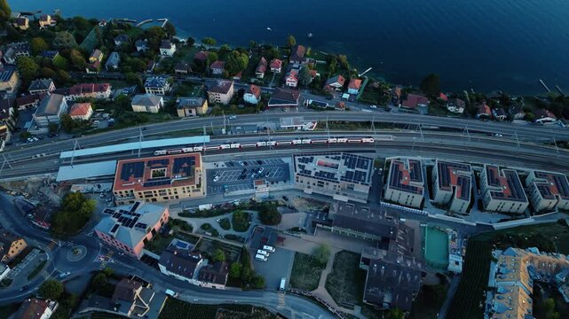 Aerial view of the Cully train station and surrounding residential area with solar panels near Lake Geneva in Bourg-en-Lavaux, Vaud, Switzerland.