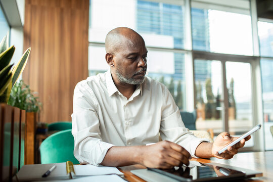 Man checking smartphone while working at office desk