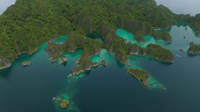 Aerial view of Piaynemo karst islands surrounded by turquoise waters and lush greenery in Distrik Waigeo Barat Kepulauan, Papua Barat, Indonesia.