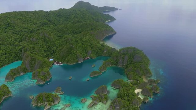 Aerial view of Piaynemo karst islands surrounded by turquoise waters and lush tropical vegetation in Distrik Waigeo Barat Kepulauan, Papua Barat, Indonesia.