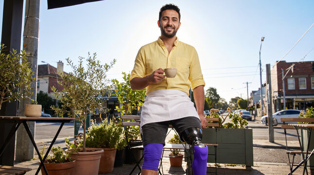 Welcoming waiter with prosthetic leg serving coffee at bright outdoor city cafe