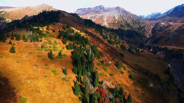 Cinematic autumn landscape of Almaty, Kazakhstan, featuring colorful mountain scenery, snowy Tien Shan peaks, Shymbulak ski resort, Medeu and the cable car.