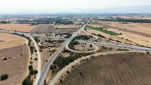 Aerial view of Trakiya Highway interchange surrounded by agricultural fields in Bulgaria.