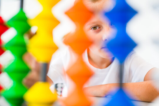 Young girl visualizing and practicing mental arithmetic with a colorful abacus, developing concentration, calculation and cognitive skills.