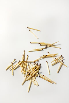 Wooden matchsticks scattered in midair against a white background. Falling objects and a concept with a minimalist composition.