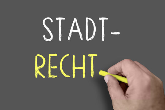 Hand schreibt Stadtrecht mit Kreide auf eine Tafel &ndash; Konzept f&uuml;r Kommunalrecht, Stadtordnung und lokale Gesetzgebung
