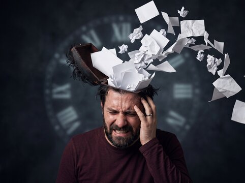 Stressed man with an open head releasing flying papers symbolizing mental overload and time pressure