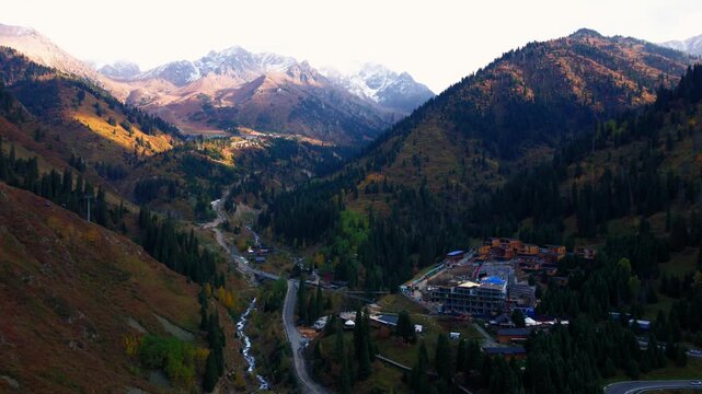 Cinematic autumn landscape of Almaty, Kazakhstan, featuring colorful mountain scenery, snowy Tien Shan peaks, Shymbulak ski resort, Medeu and the cable car.