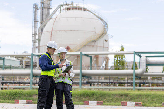 Two petroleum engineers having a discussion at oil refinery site